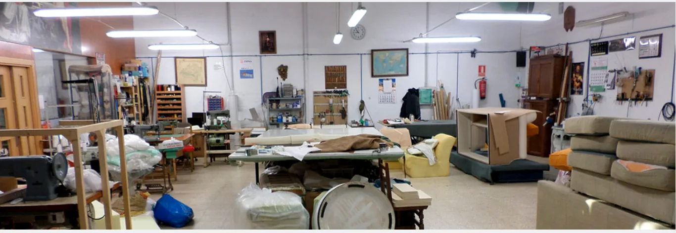 Taller de Velvet con mesas de trabajo, máquinas de costura y muebles en proceso